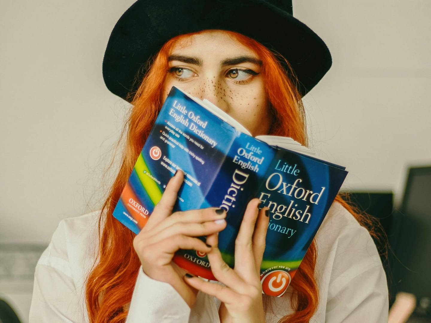 Woman holding the Oxford English Dictionary in front of her