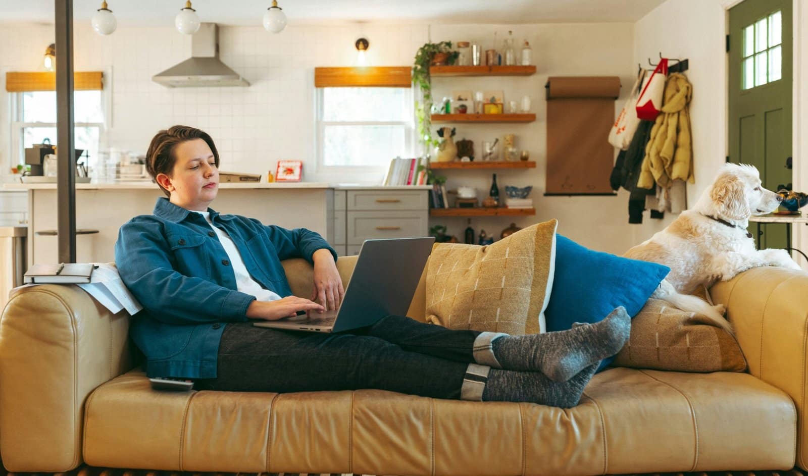 A woman sitting on a couch using a laptop computer